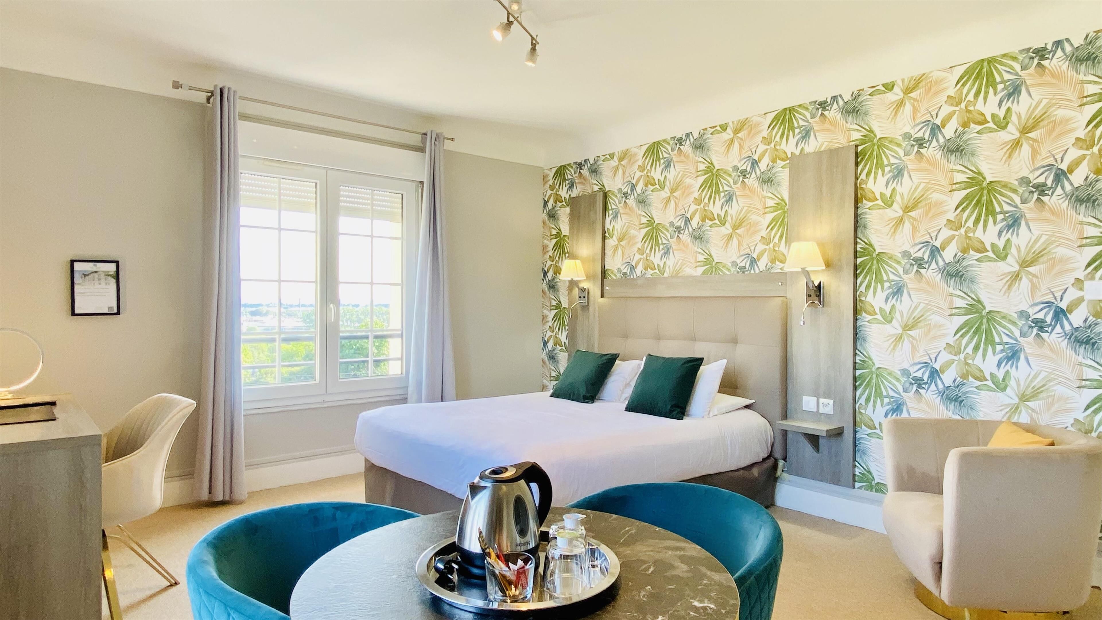 Una habitación de hotel con cama, escritorio, silla y mesita con bandeja.