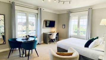 A hotel room with a bed, a desk, a chair, and a table.