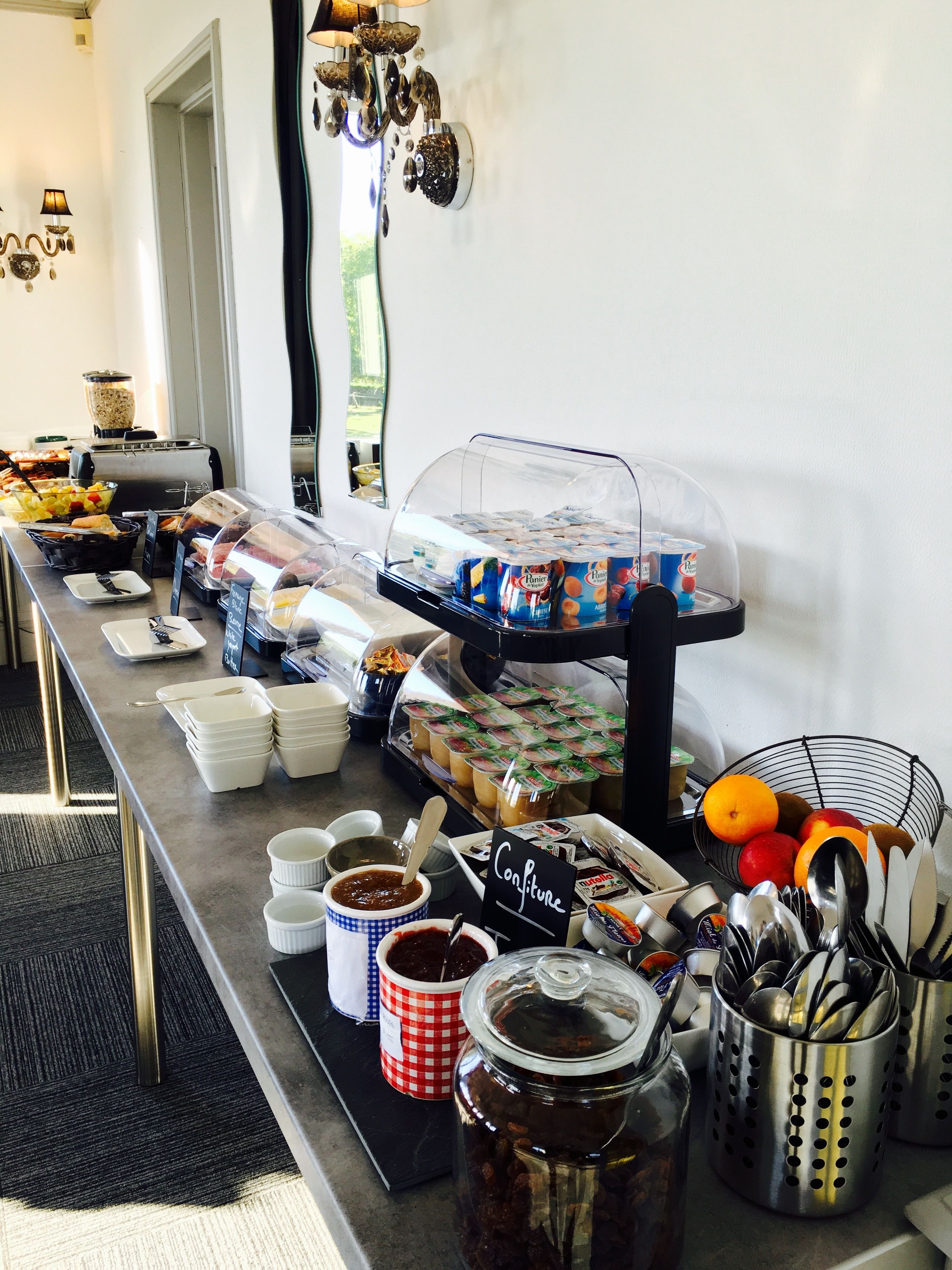 Una barra de buffet con diversos alimentos, salsas y utensilios.