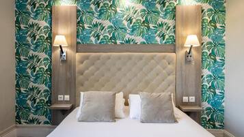 A bedroom with a tufted headboard, two bedside lamps, and a bed with pillows.