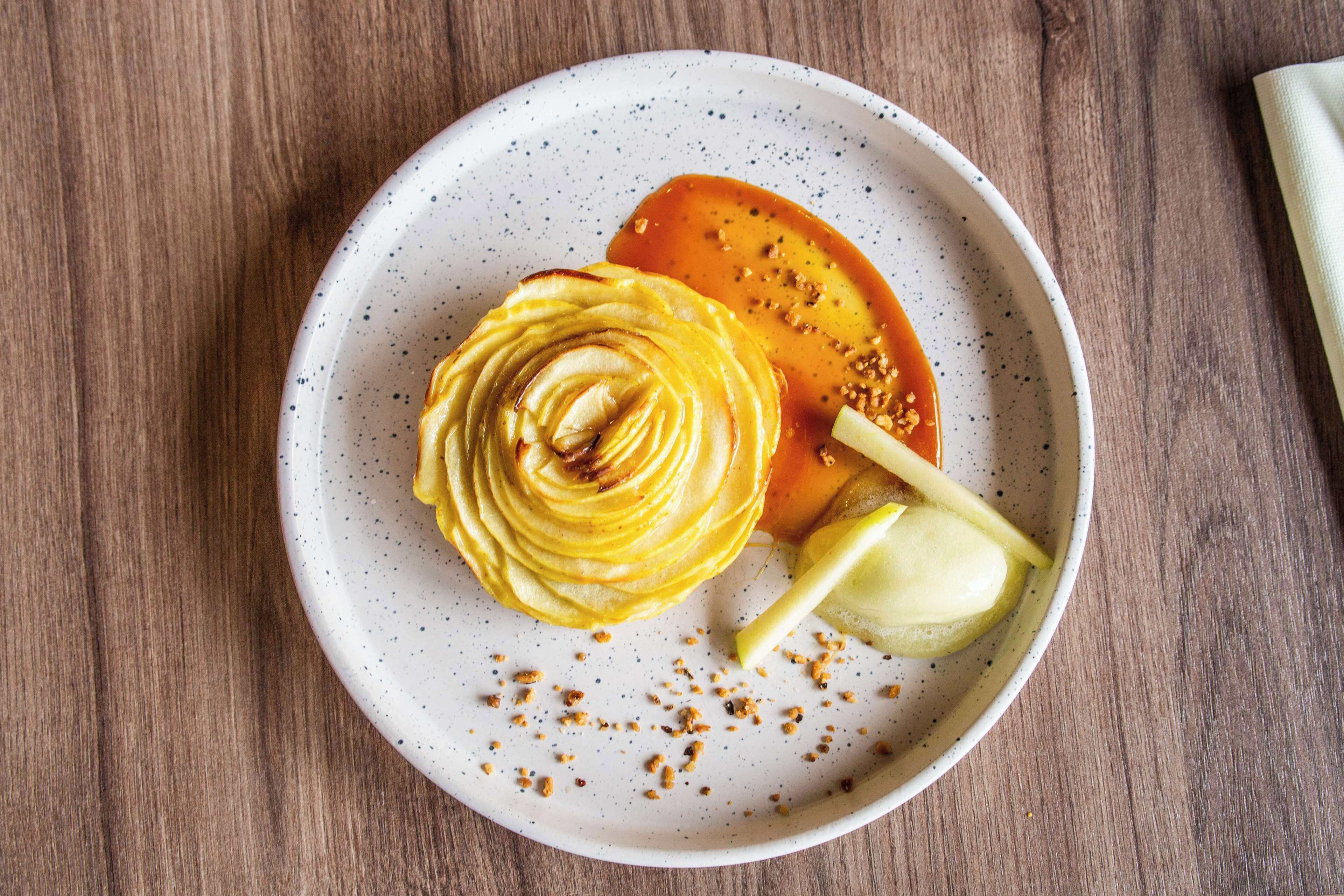 A plate with a dessert on a speckled ceramic plate.
