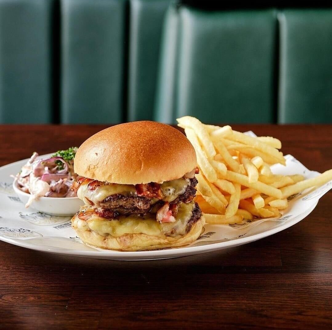 A plate with a burger and fries on a table.