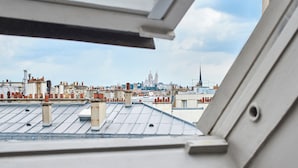 Vista desde una ventana que muestra un paisaje urbano con una cúpula y aguja destacadas a lo lejos.