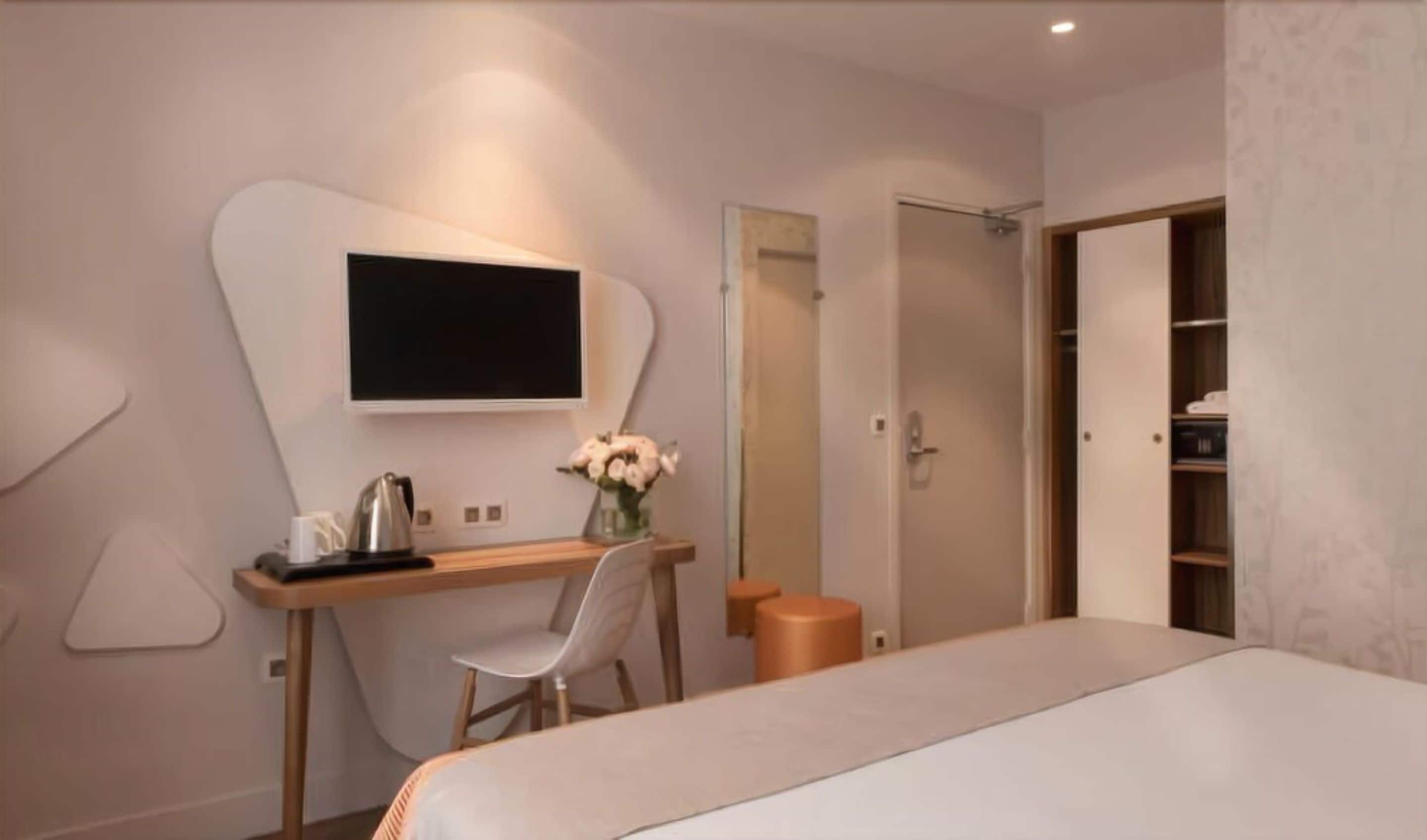 Une chambre à coucher moderne, comprenant un lit, un bureau avec une chaise, une télévision et une armoire.