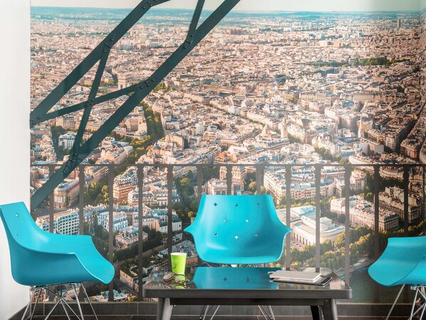 Enjoy a panoramic city view from this stylish room with a glass table and two chairs.