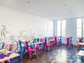 Guests can dine in comfort at this stylish dining area with tables and colorful chairs.