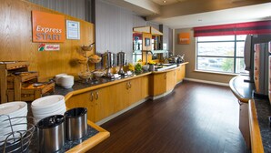 A hotel breakfast area with a buffet setup, including trays, bowls, and a coffee station. - Holiday Inn Express London Luton Airport by IHG (Luton)