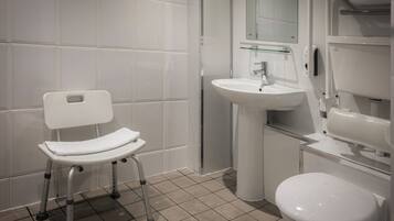 A modern bathroom with a white toilet, a sink, and a glass shower enclosure.
