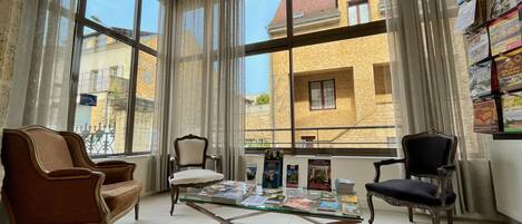 A room with large windows, a glass coffee table, and two chairs.