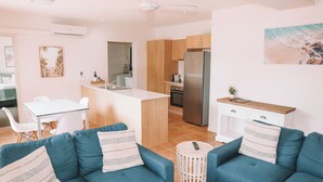 A modern apartment with a kitchen, dining area, and living room.