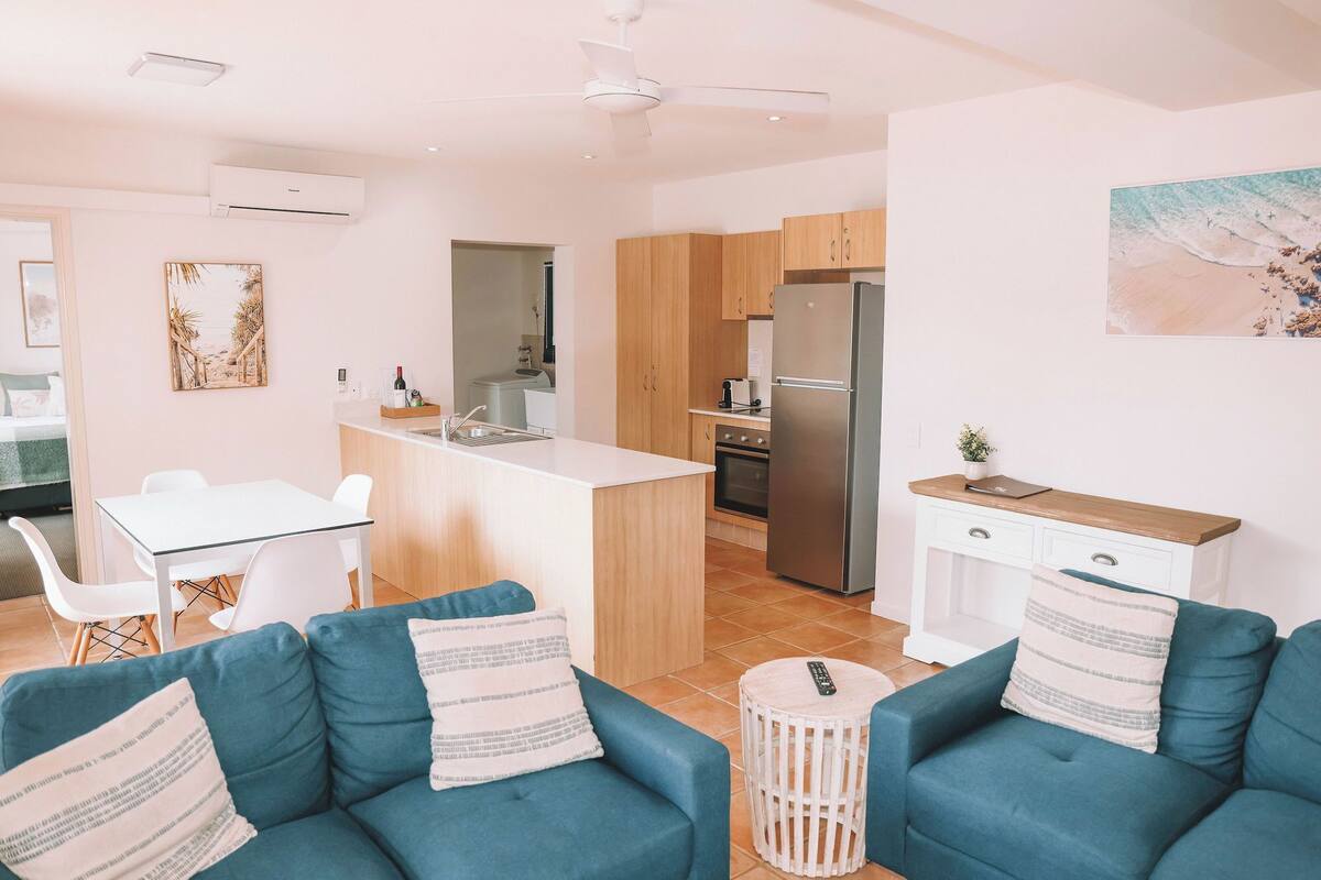 A modern apartment with a kitchen, dining area, and living room.