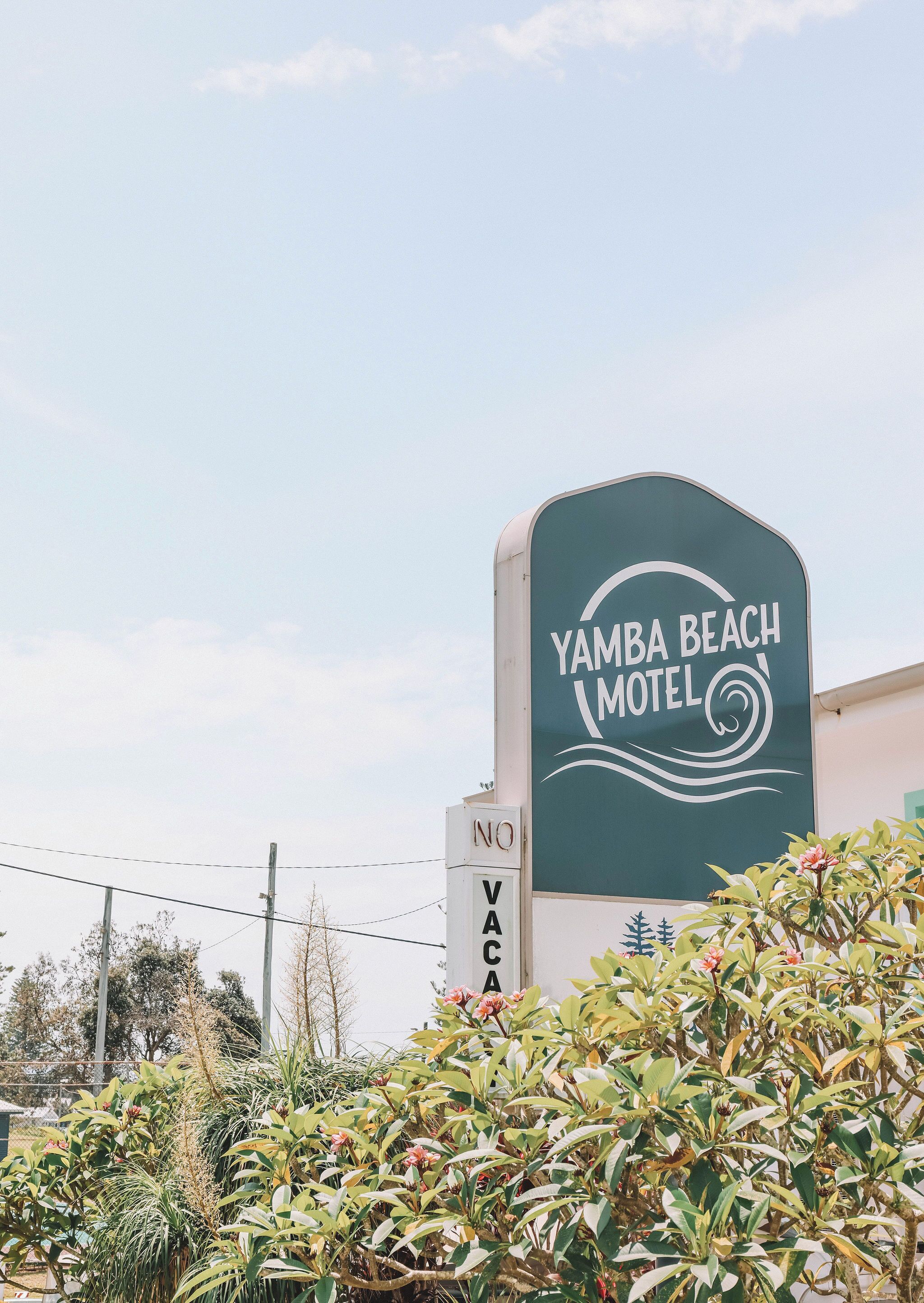 Placa de motel com 'YAMBA BEACH MOTEL' e um aviso de 'SEM FÉRIAS'.