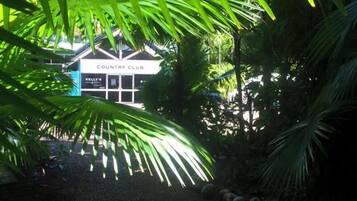 Un camino conduce a un edificio que dice 'COUNTRY CLUB', con un cartel que indica 'KELLY'S'.