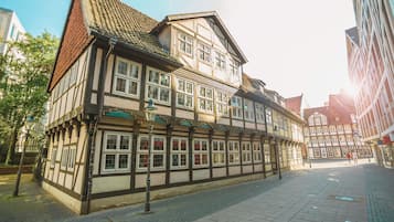 A traditional half-timbered building with multiple windows and a cobblestone street.