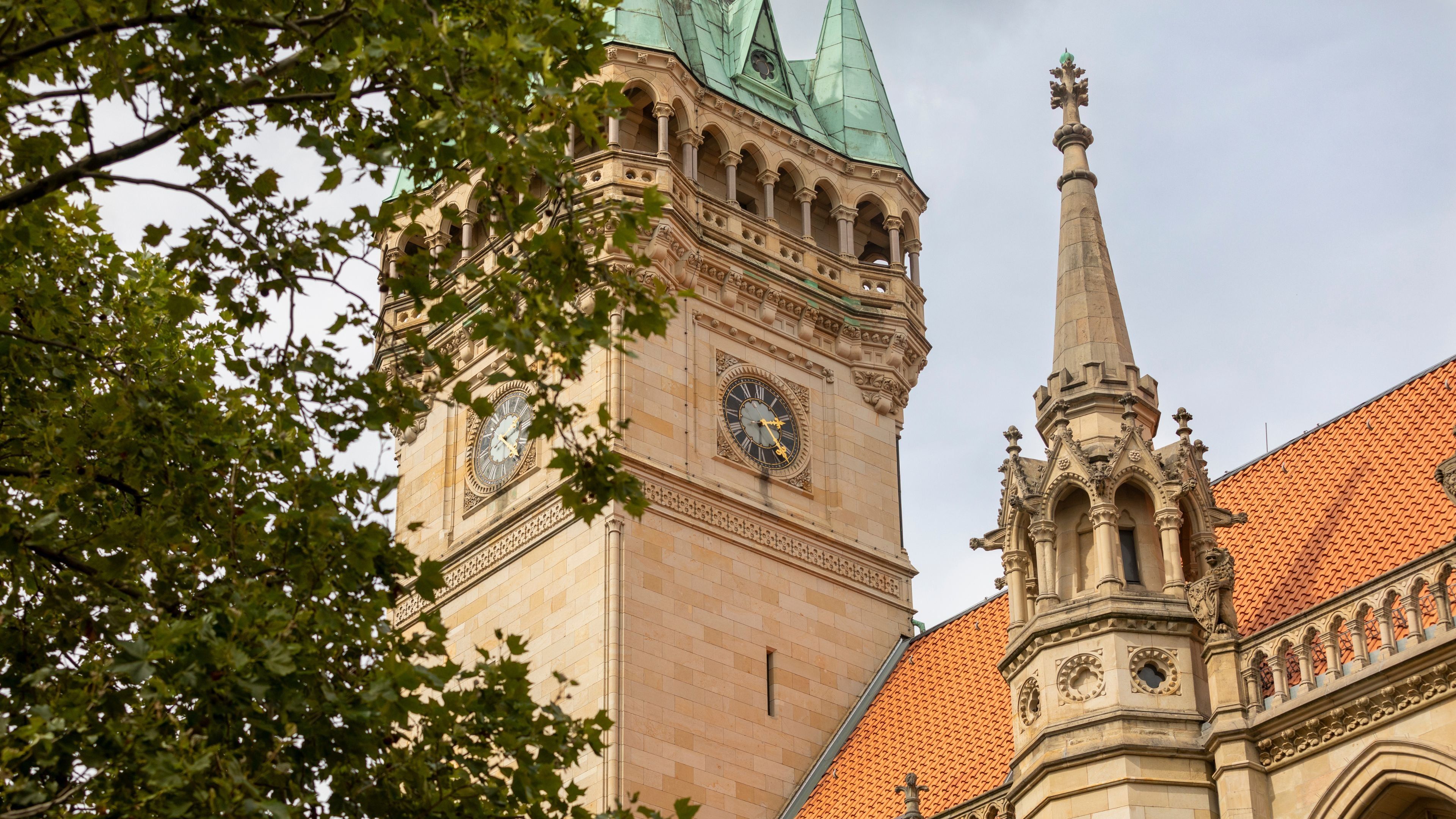 A historic building with a prominent clock tower and a spire.