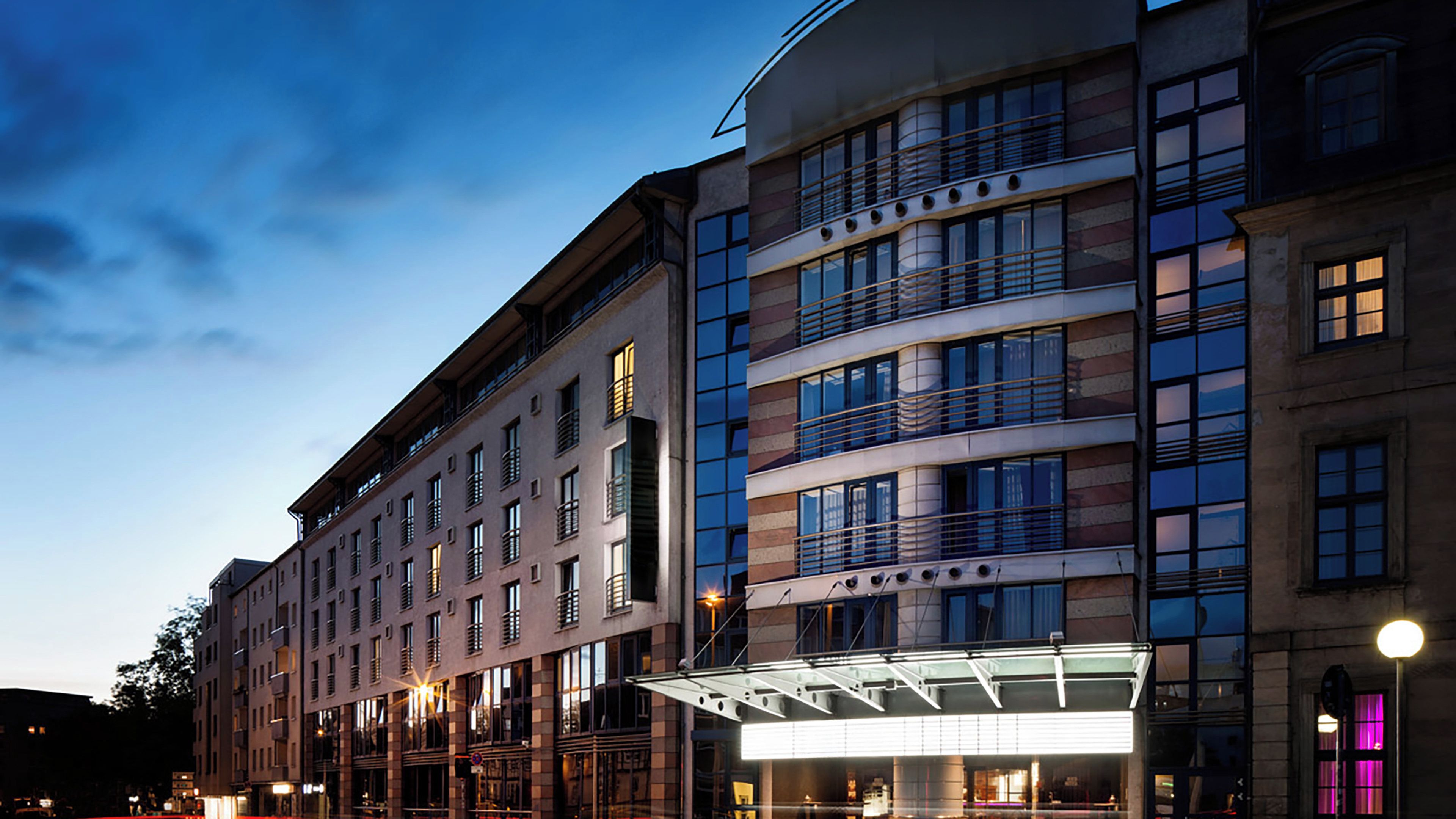 A multi-story hotel with a modern facade, large windows, and a prominent entrance with a glass canopy.