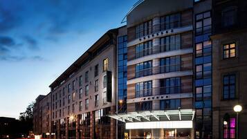 A multi-story hotel with a modern facade, large windows, and a prominent entrance with a glass canopy.