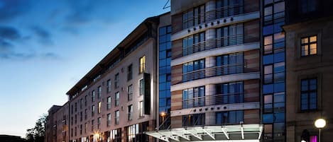 A multi-story hotel with a modern facade, large windows, and a prominent entrance with a glass canopy.