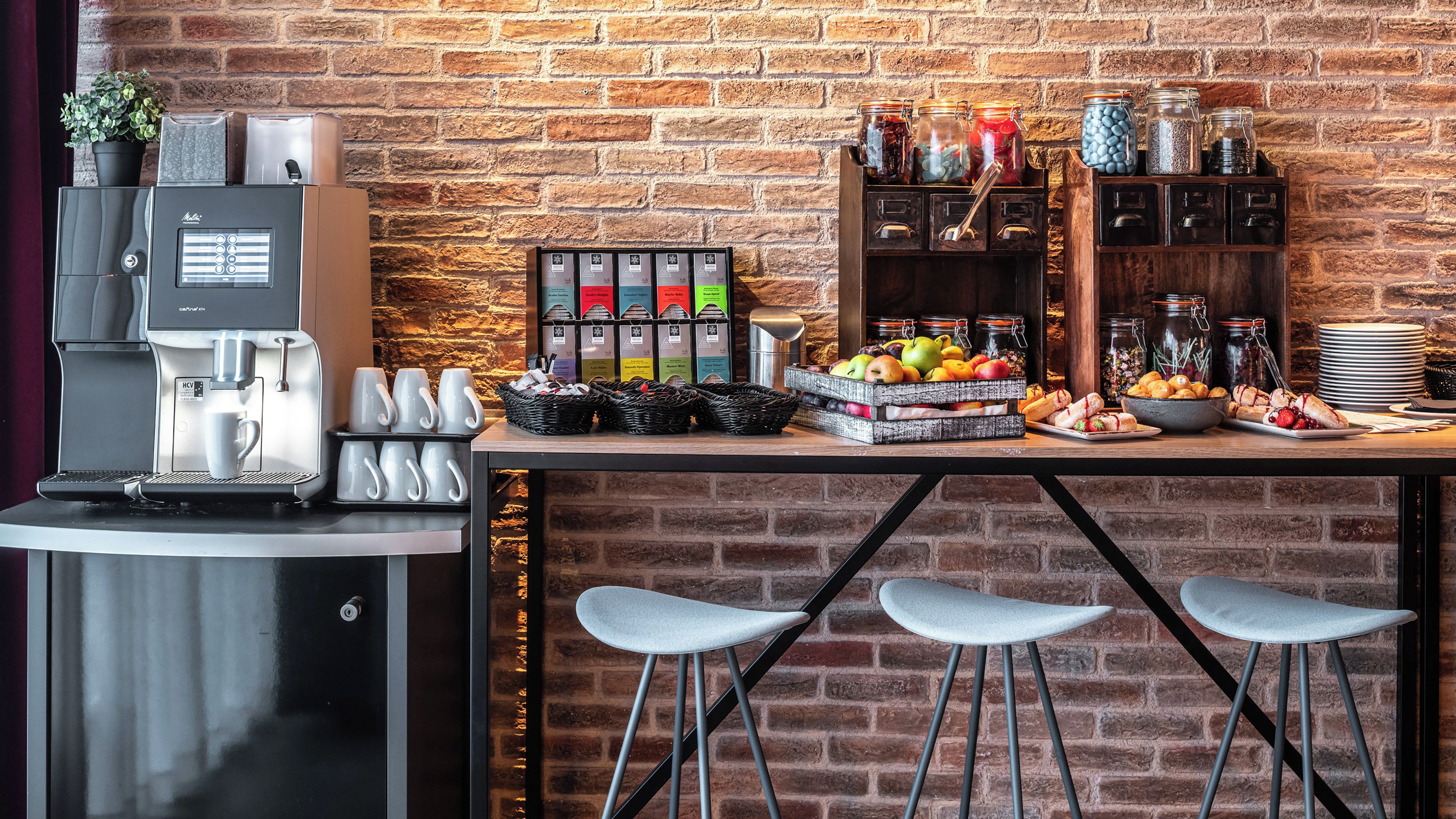A coffee station with a coffee machine, mugs, and a selection of teas.