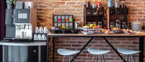 A coffee station with a coffee machine, mugs, and a selection of teas.