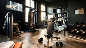 A gym with exercise equipment, a treadmill, and weights. - pentahotel Braunschweig (Braunschweig)