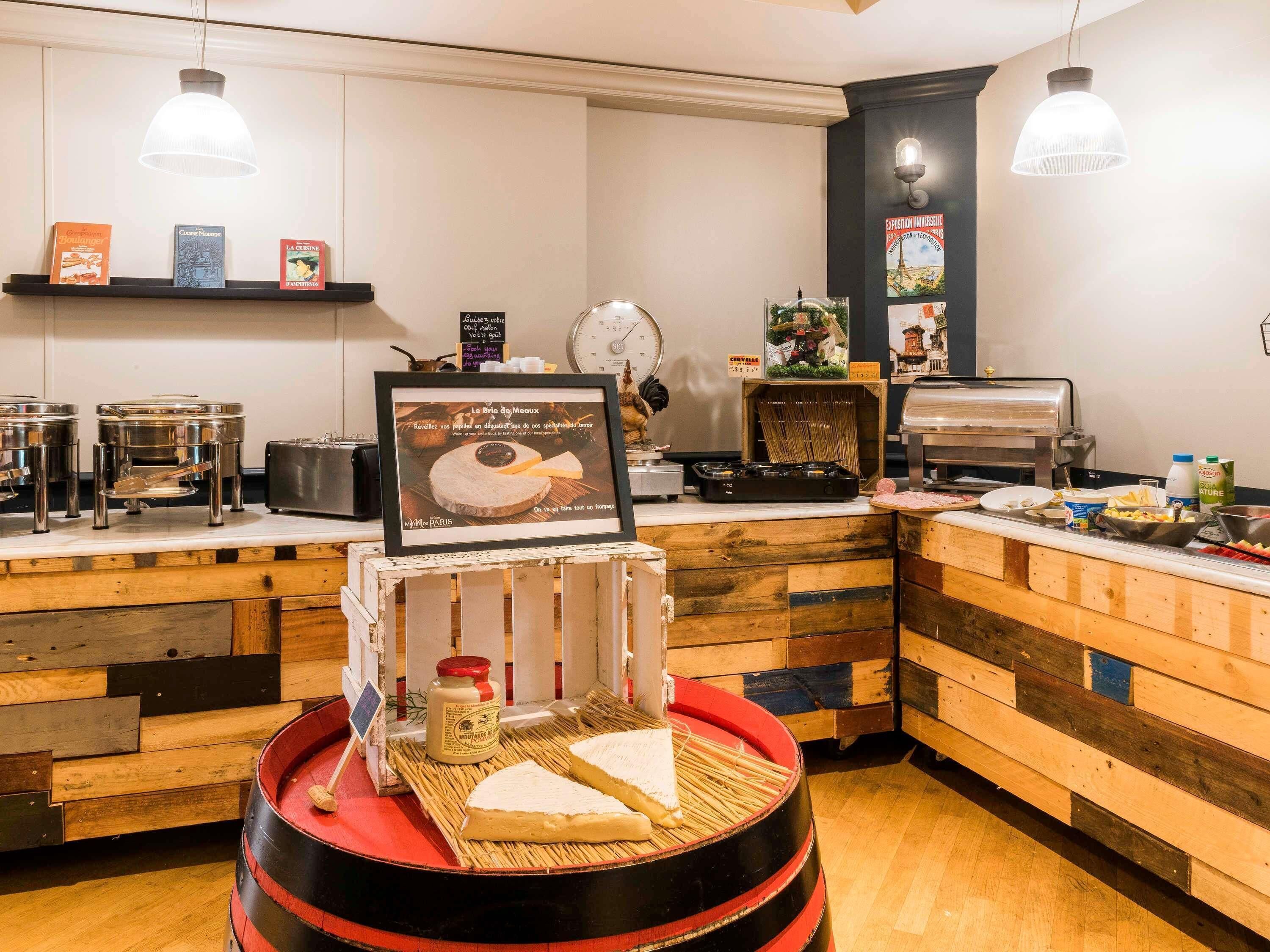 A breakfast bar with a wooden counter, a framed menu, and a red barrel.