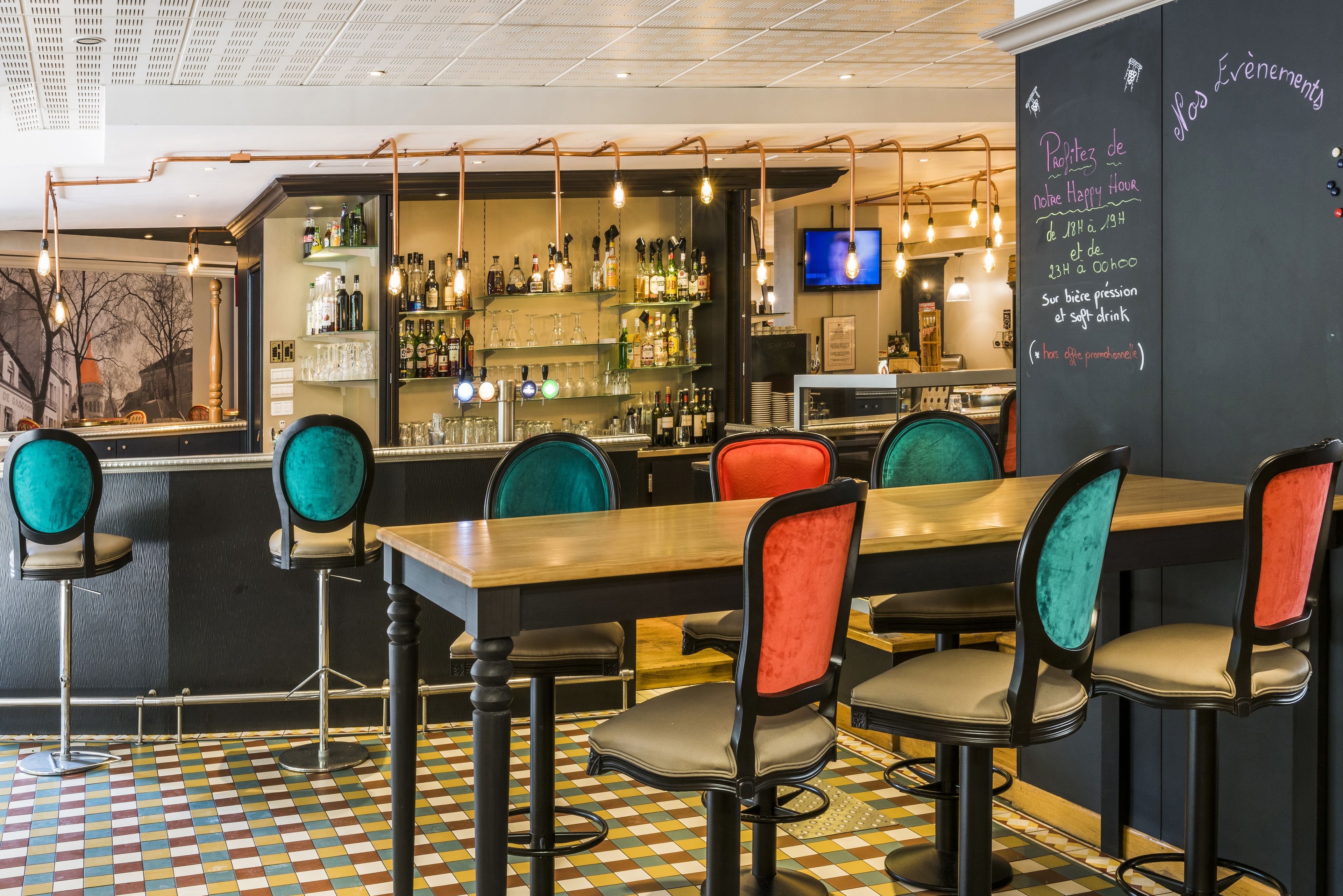A bar area with a checkered floor, bar stools, and a chalkboard menu.