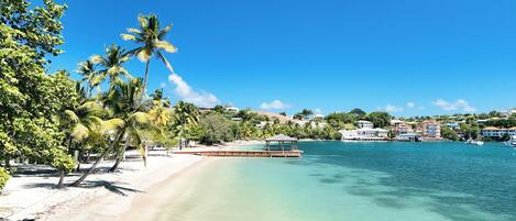 En la playa, arena blanca, sillas reclinables de playa, toallas de playa