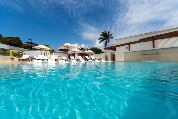 Piscine extérieure, parasols de plage, chaises longues