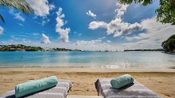 On the beach, white sand, sun loungers, beach towels