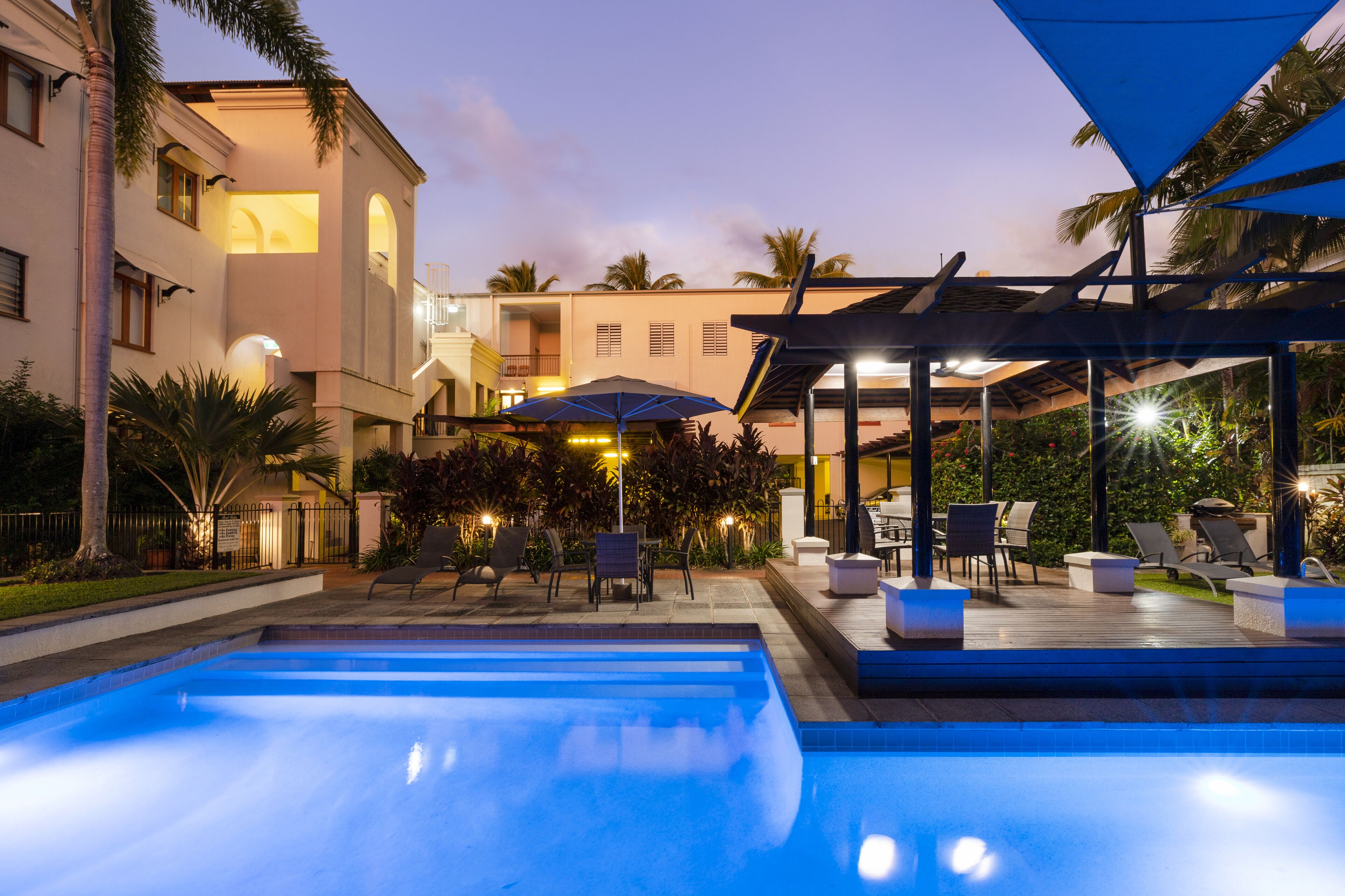 Una piscina al aire libre, sombrillas, sillones reclinables de piscina