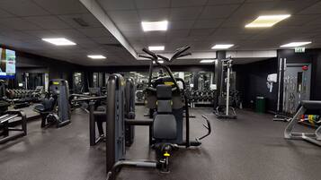 A gym with various exercise machines, weights, and cardio equipment.