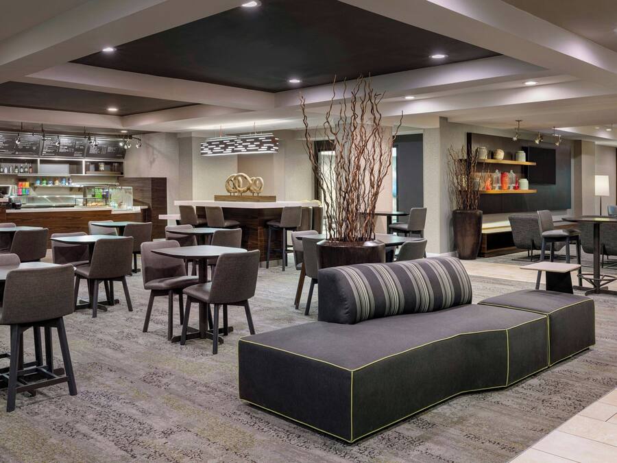 A modern lounge area with a bar, seating arrangements, and a decorative centerpiece.