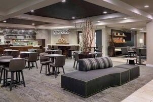 A modern lounge area with a bar, seating arrangements, and a decorative centerpiece.