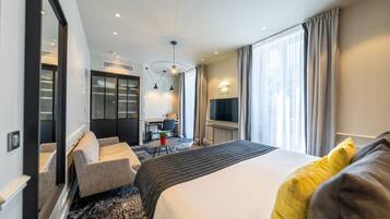 Habitación de hotel con una cama grande, un escritorio, una silla y un televisor.