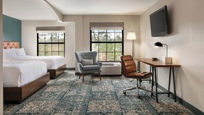 A hotel room with two beds, a desk, a chair, a TV, and large windows. - Four Points by Sheraton Raleigh Arena (Raleigh)