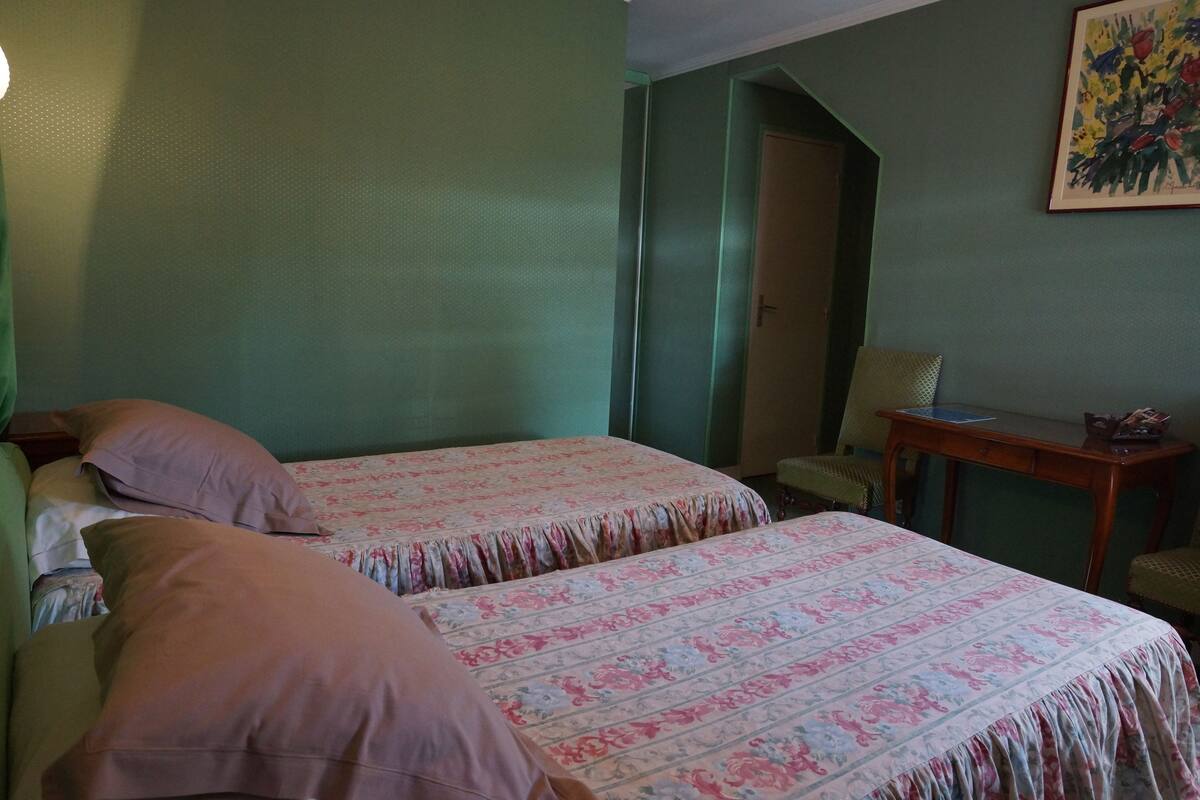 A room with two beds, a desk, and a chair.