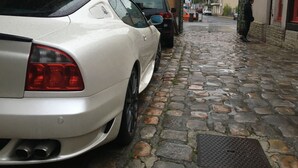 A narrow cobblestone street with parked cars and buildings on either side. - Hotel La Diligence (Honfleur)