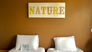 A hotel room with two beds, a brown wall, and a sign that reads "NATURE". - Kyriad Montpellier Centre - Antigone (Montpellier)