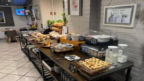 A buffet setup with various food items, a coffee station, and a sign indicating a home-like atmosphere. - Kyriad Montpellier Centre - Antigone (Montpellier)