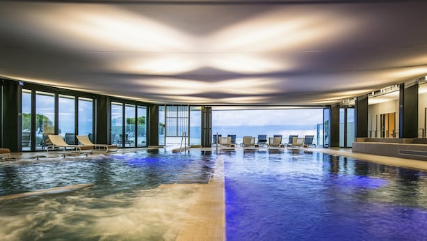 An indoor swimming pool with lounge chairs and a view of the ocean. - La Grande Terrasse Hotel & Spa La Rochelle - MGallery Collection (Chatelaillon-Plage)