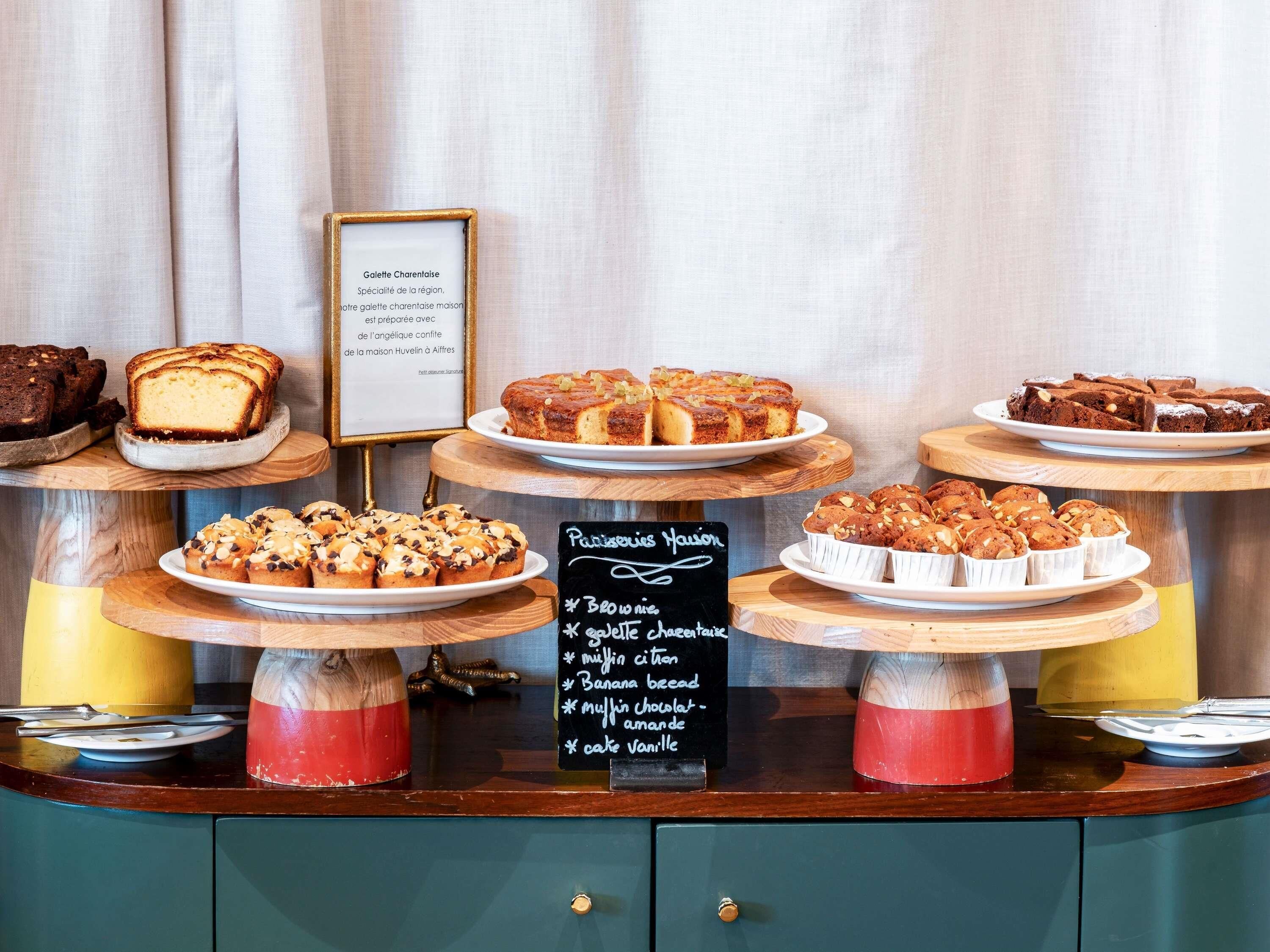 A bakery display with various baked goods and a chalkboard menu listing items like brownies and muffins.