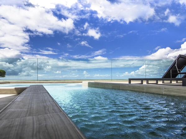Una piscina techada, sillones reclinables de piscina
