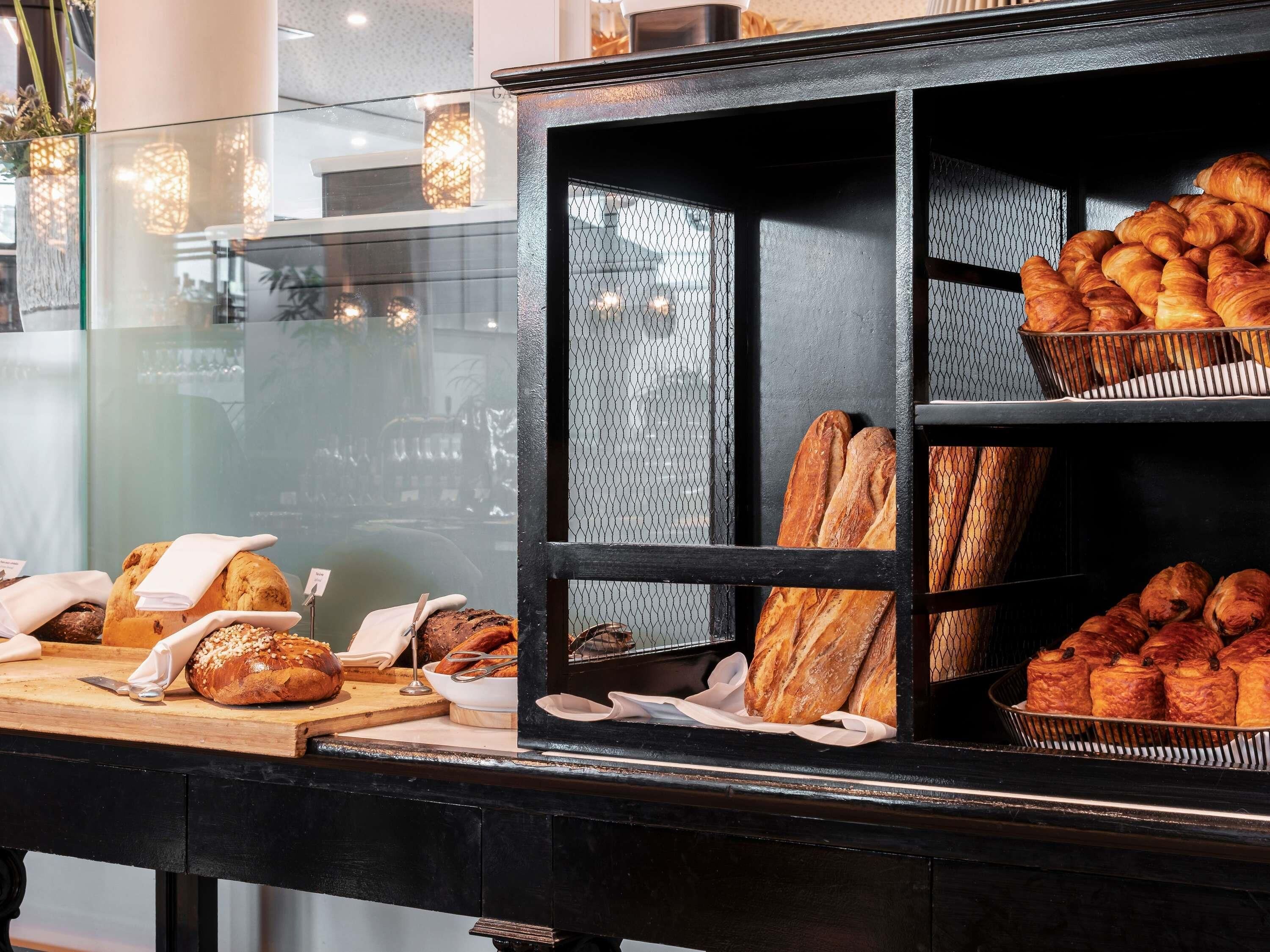 Una vitrina de panadería con panes y pasteles varios.