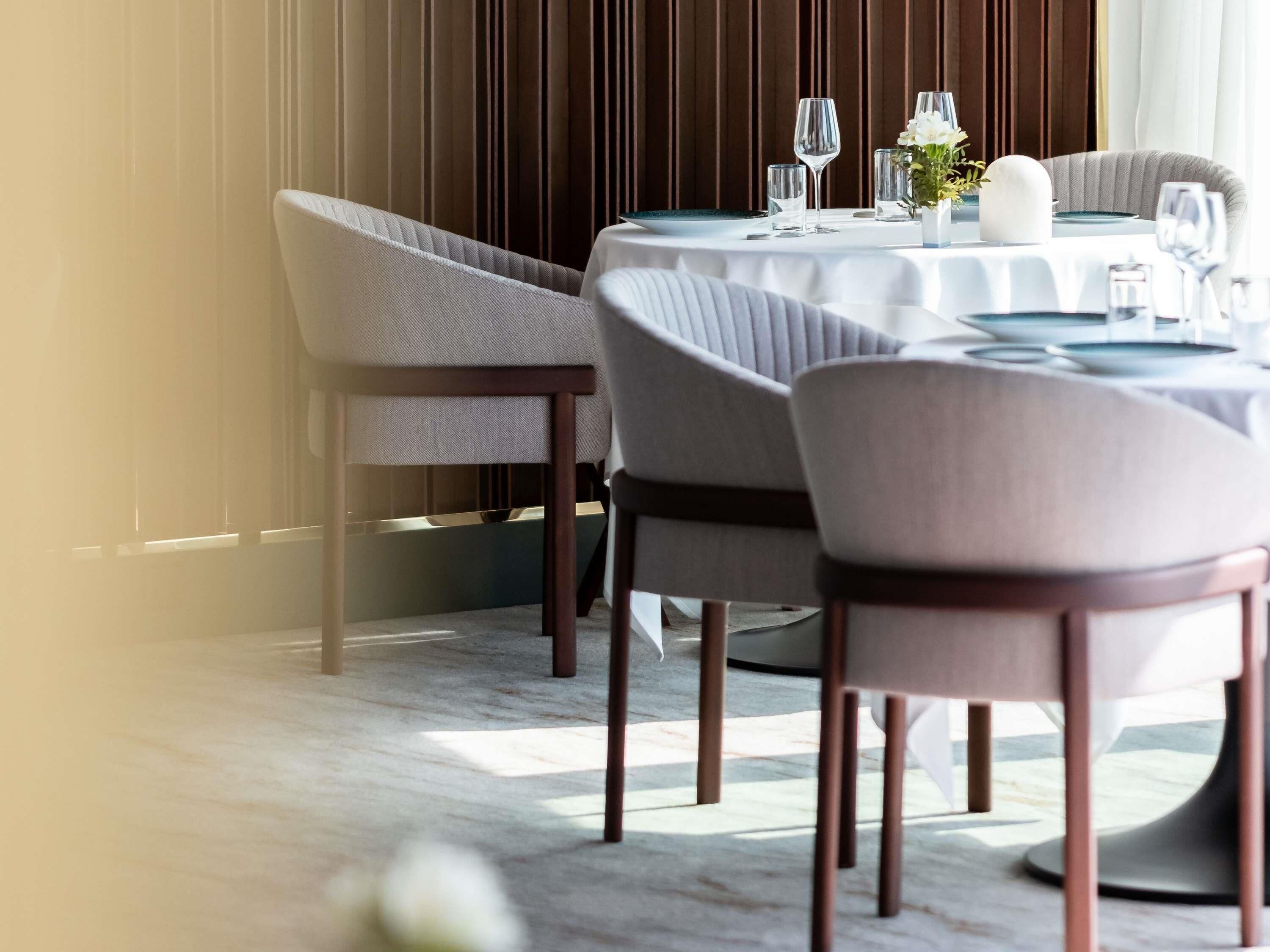 A dining area with round tables, chairs, and a decorative vase.