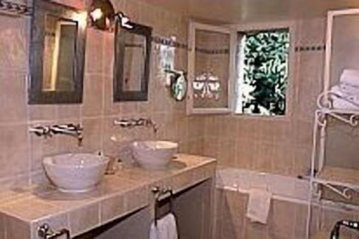 A bathroom with two sinks, a window, and a towel rack.