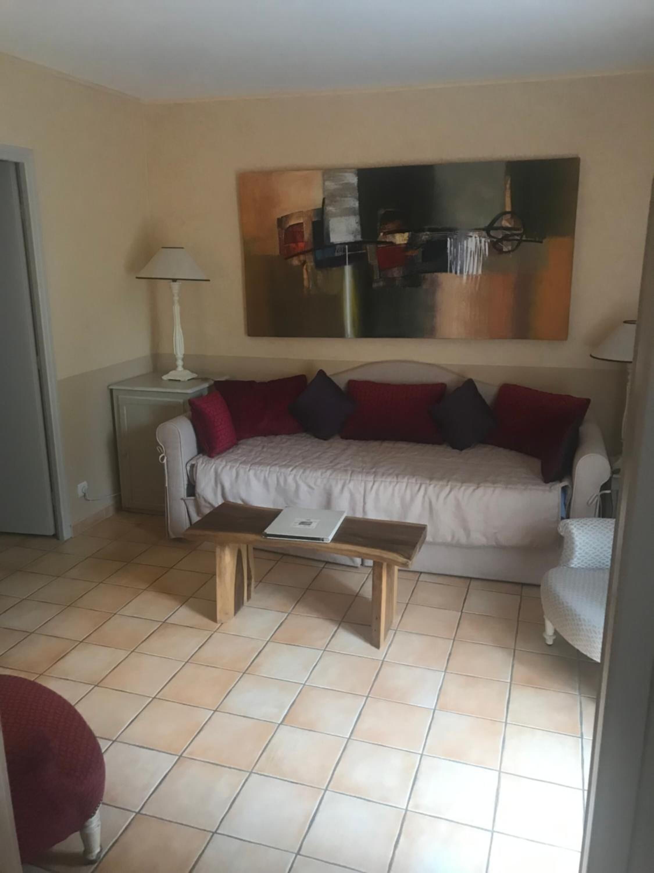 Una sala de estar con un sofá, una mesa de centro y un cuadro en la pared.