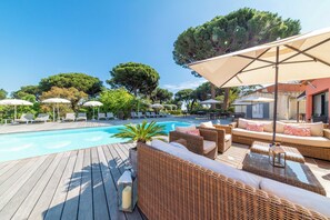 Una piscina al aire libre de temporada, sillones reclinables de piscina