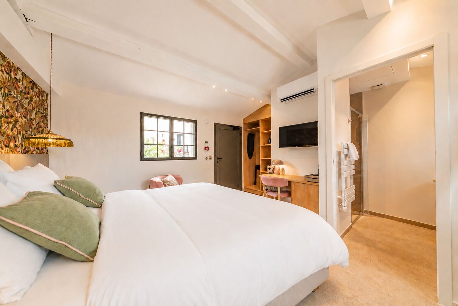 Une chambre avec un grand lit, un bureau, une télévision et une armoire.