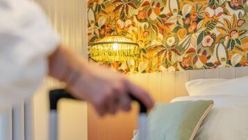 Una camera d'albergo con un letto, una parete decorativa e un lampadario.